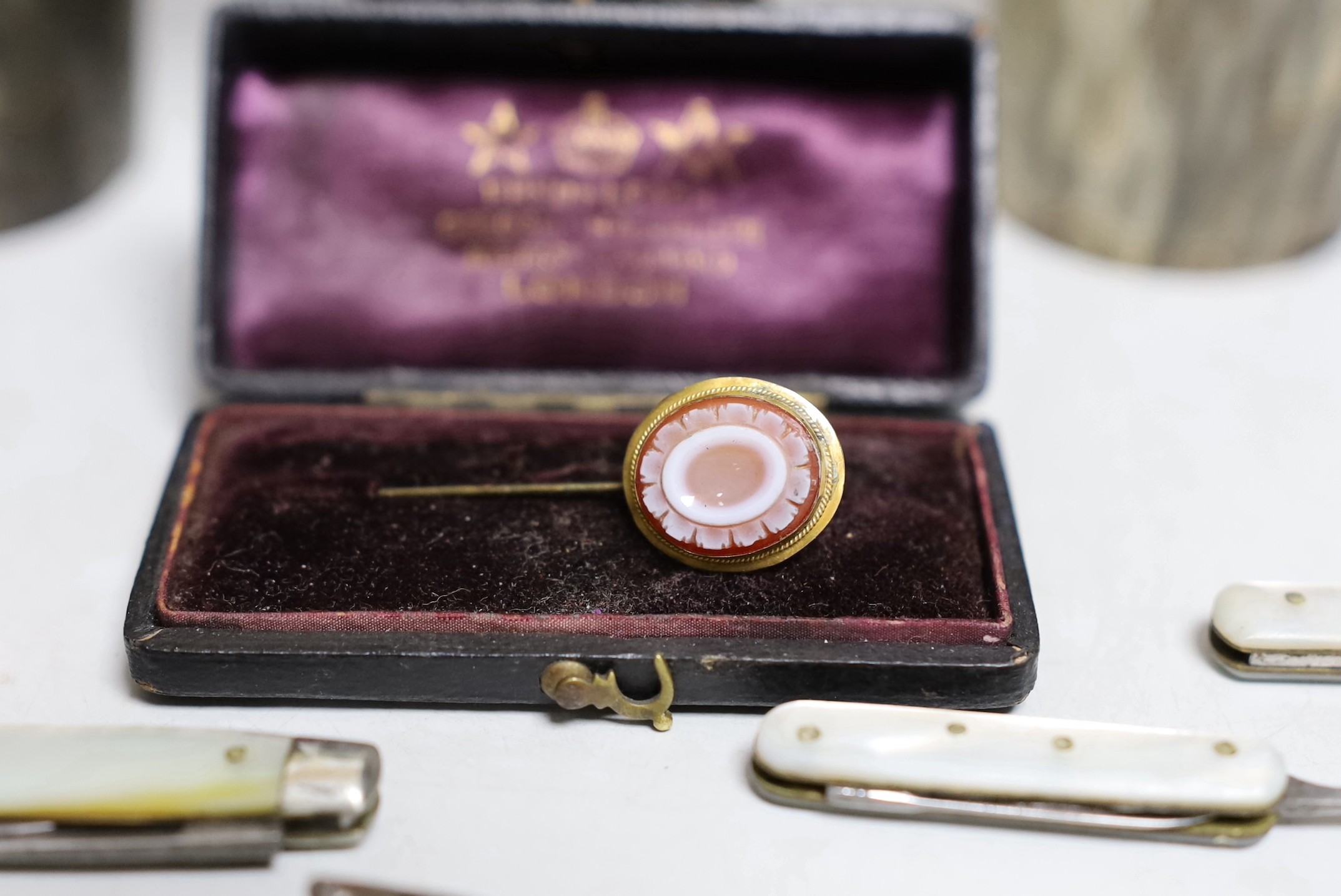 Two Edwardian silver mounted horn beakers, Haseler Brothers, Chester, 1903, largest 12.3cm, a similar Victorian beaker, a sardonyx mounted stick pin, nine assorted penknives/nail implements and an Edwardian silver and en